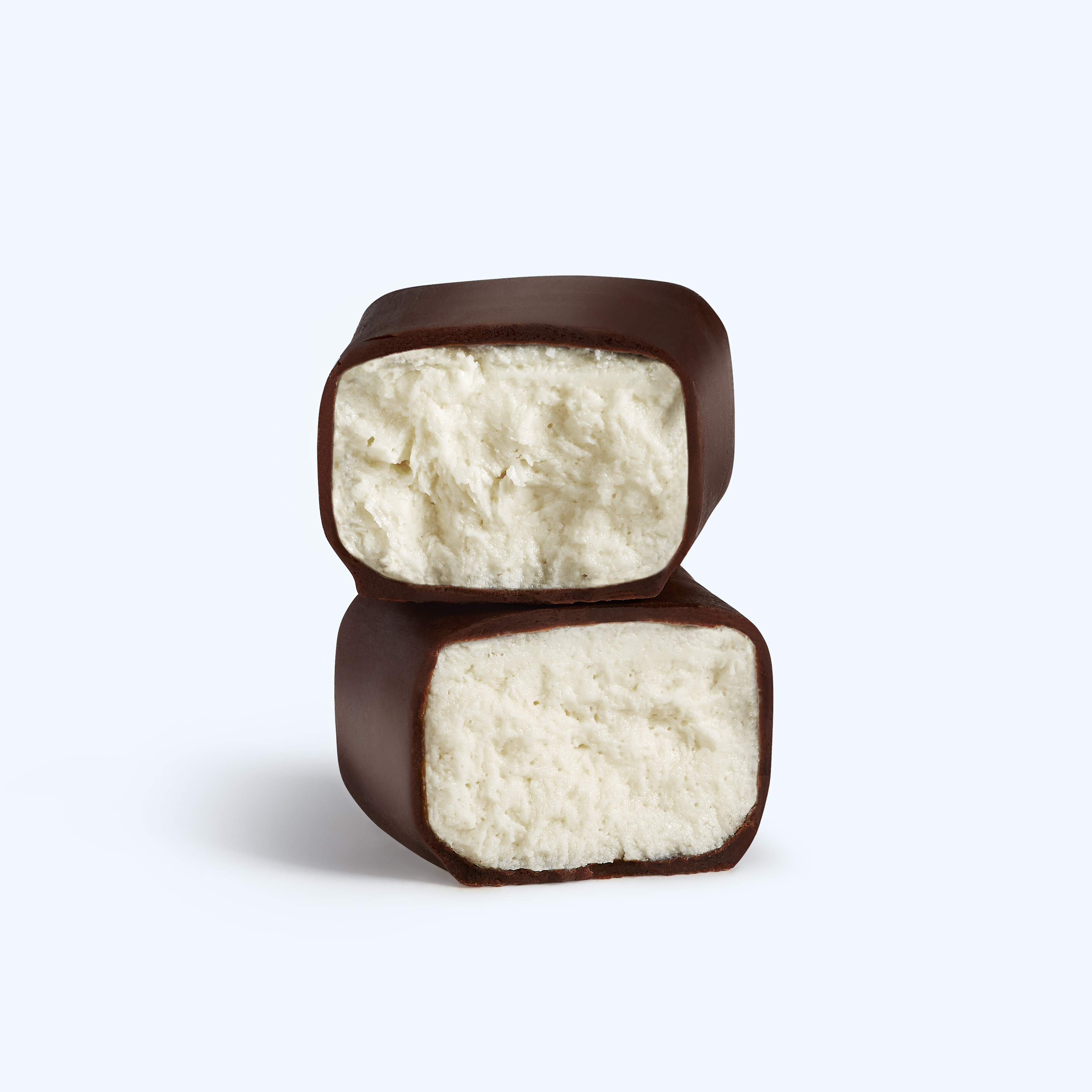 Two vanilla YAAR bar halves showing the creamy yogurt center and chocolate shell